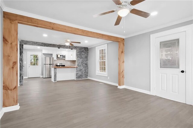 unfurnished living room featuring ceiling fan, dark hardwood / wood-style floors, and ornamental molding