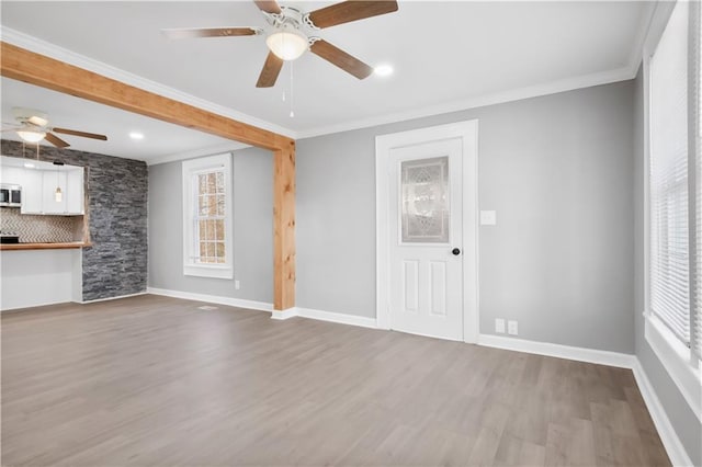 unfurnished living room featuring crown molding, hardwood / wood-style floors, and ceiling fan