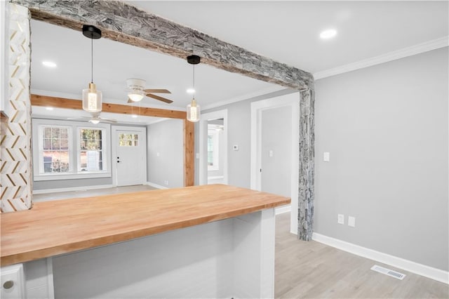 kitchen featuring ceiling fan, wooden counters, ornamental molding, decorative light fixtures, and light wood-type flooring