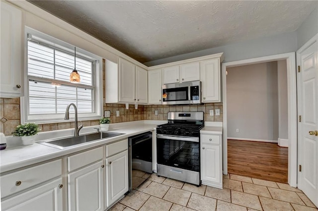 1965 Sterling Creek Ct, Snellville, GA 30078 - kitchen featuring stainless steel appliances, a sink, tasteful backsplash, white cabinets, and light countertops