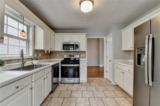1965 Sterling Creek Ct, Snellville, GA 30078 - kitchen with appliances with stainless steel finishes, a sink, tasteful backsplash, light countertops, and white cabinetry
