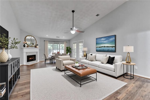 1965 Sterling Creek Ct, Snellville, GA 30078 - living room featuring ceiling fan, wood finished floors, a fireplace with flush hearth, baseboards, and high vaulted ceiling