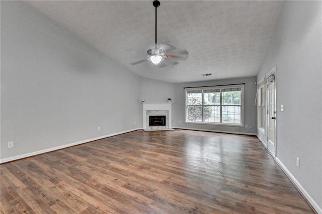 1965 Sterling Creek Ct, Snellville, GA 30078 - unfurnished living room featuring dark wood-style flooring, a ceiling fan, a fireplace, baseboards, and a textured ceiling