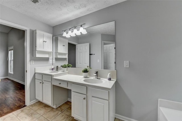 1965 Sterling Creek Ct, Snellville, GA 30078 - bathroom with a textured ceiling, double vanity, tile patterned floors, and baseboards