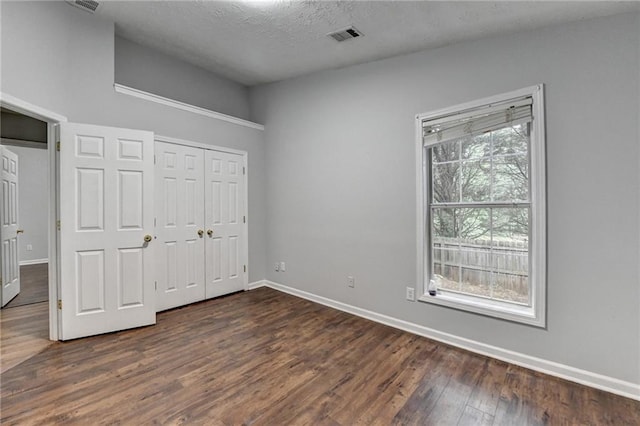1965 Sterling Creek Ct, Snellville, GA 30078 - unfurnished bedroom featuring dark wood-style floors, baseboards, a closet, and a textured ceiling