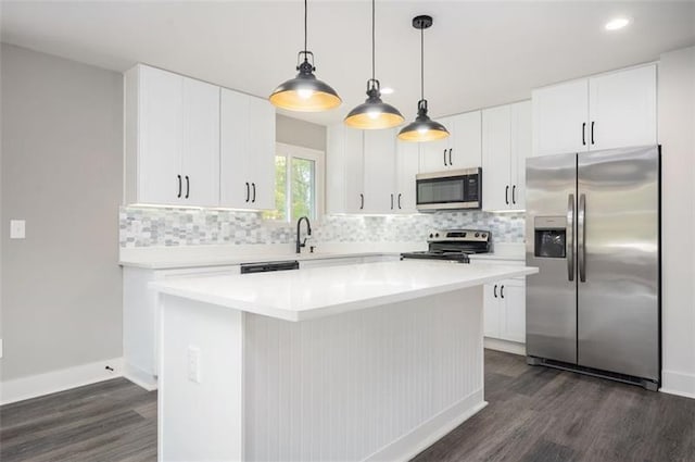 kitchen with tasteful backsplash, stainless steel appliances, a center island, and white cabinets