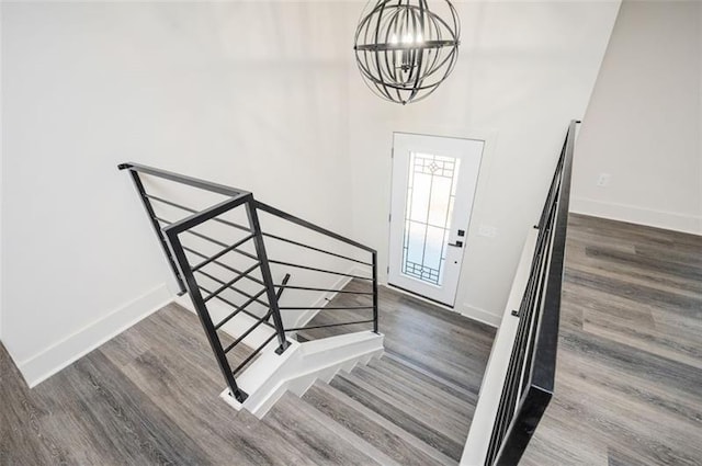 entryway with dark wood-type flooring and an inviting chandelier