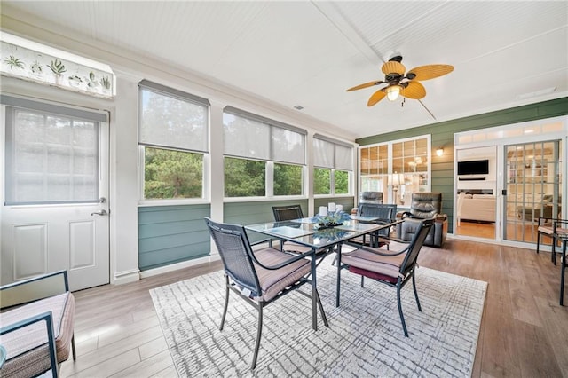 sunroom / solarium featuring a ceiling fan and outdoor dining space