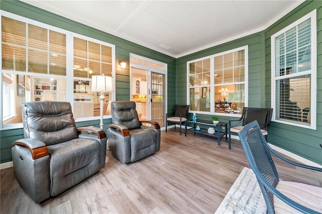 sunroom / solarium featuring wood finished floors and wood walls
