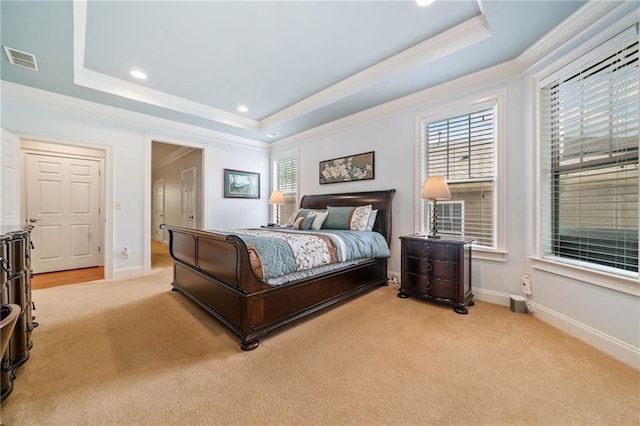 bedroom with a tray ceiling, ornamental molding, light colored carpet, multiple windows, and recessed lighting