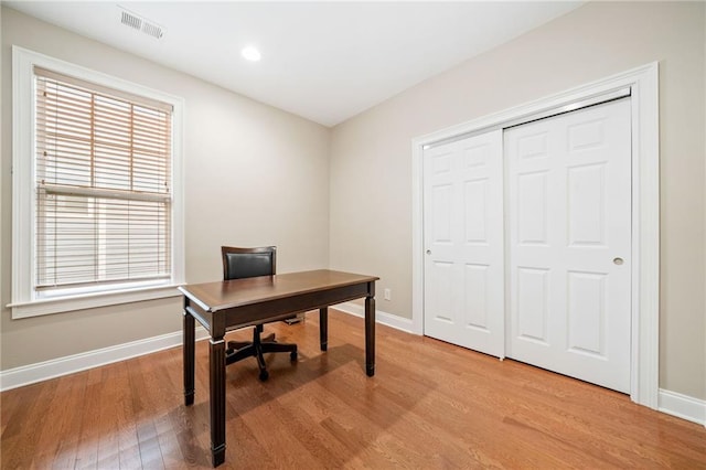 office space featuring light wood finished floors, baseboards, healthy amount of natural light, and recessed lighting