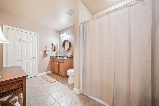 bathroom with vanity, toilet, and baseboards
