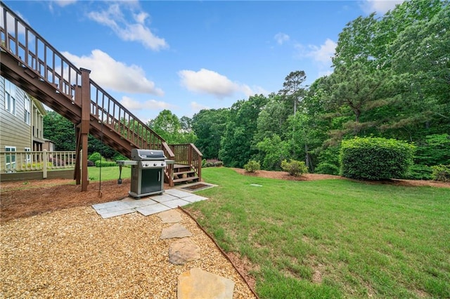 view of green lawn featuring stairway