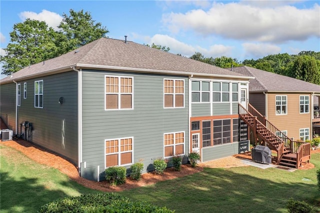 back of property with stairs, a shingled roof, a yard, and central air condition unit