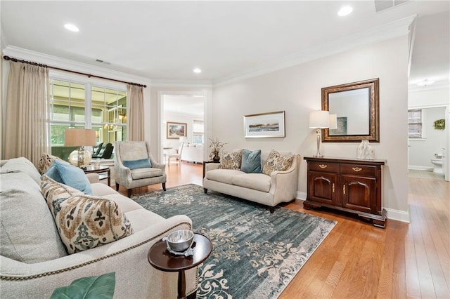 living room with light wood-style floors, plenty of natural light, crown molding, baseboards, and recessed lighting