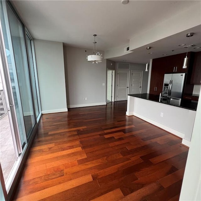 kitchen featuring dark wood-type flooring, dark brown cabinets, and stainless steel fridge