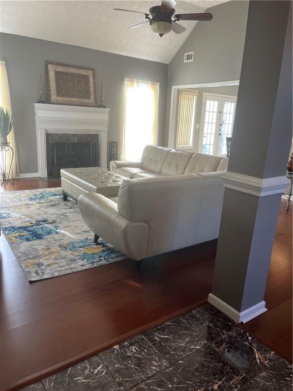 living room with ceiling fan, vaulted ceiling, and a high end fireplace