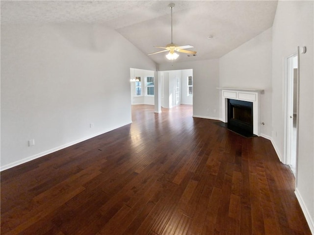 unfurnished living room featuring vaulted ceiling, dark hardwood / wood-style floors, and ceiling fan