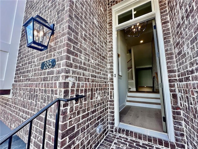 entrance to property featuring brick siding