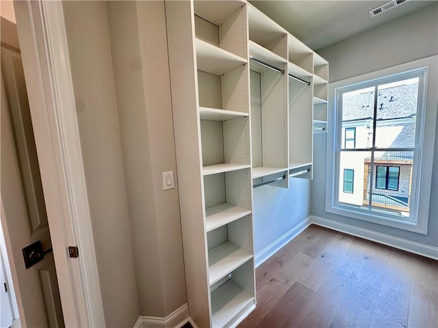 walk in closet with wood finished floors and visible vents