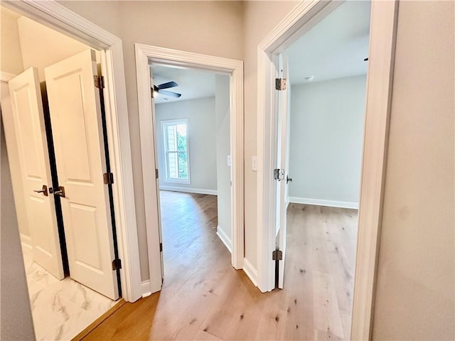hall featuring baseboards and wood finished floors