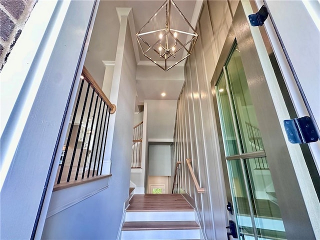 staircase with a notable chandelier