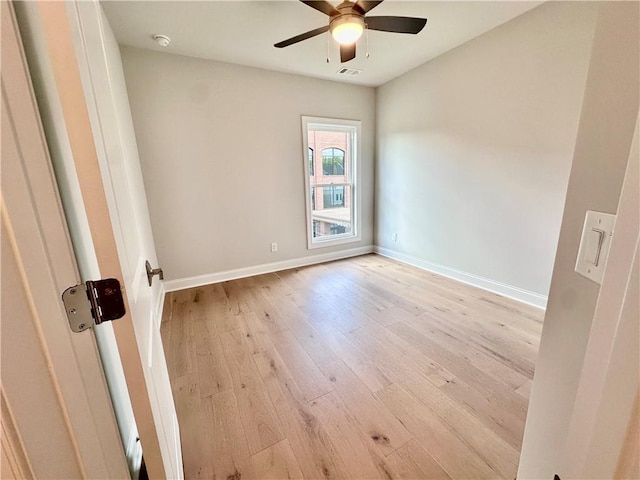 empty room with visible vents, light wood-type flooring, baseboards, and ceiling fan