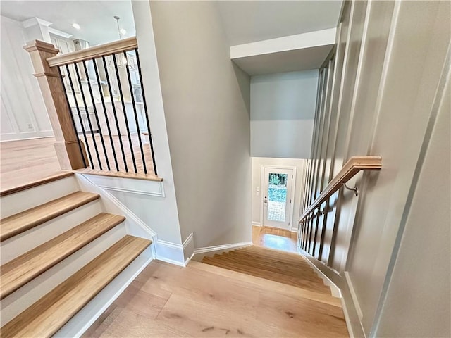 staircase with wood finished floors and baseboards