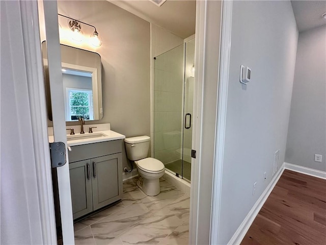 bathroom featuring baseboards, toilet, vanity, marble finish floor, and a stall shower