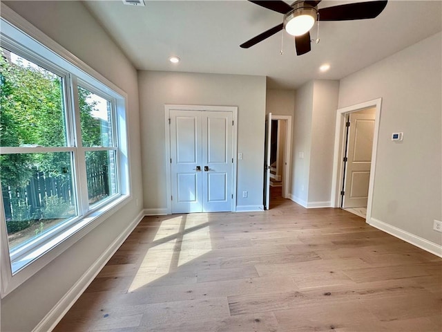 unfurnished bedroom featuring light wood-style flooring, a closet, baseboards, and recessed lighting