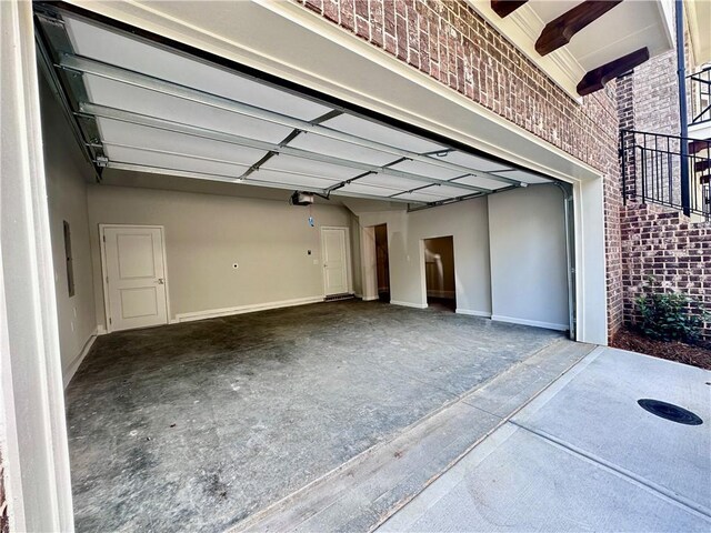 garage featuring a garage door opener and baseboards