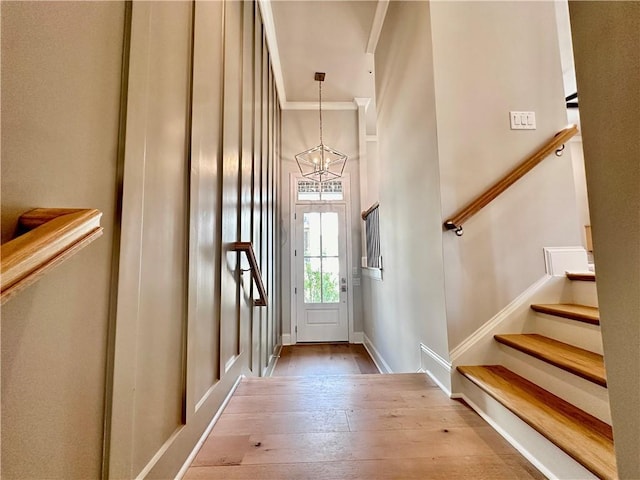 foyer with a notable chandelier, baseboards, stairway, a high ceiling, and wood finished floors
