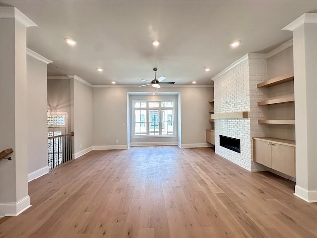 unfurnished living room featuring baseboards, recessed lighting, a ceiling fan, light wood-style floors, and a brick fireplace