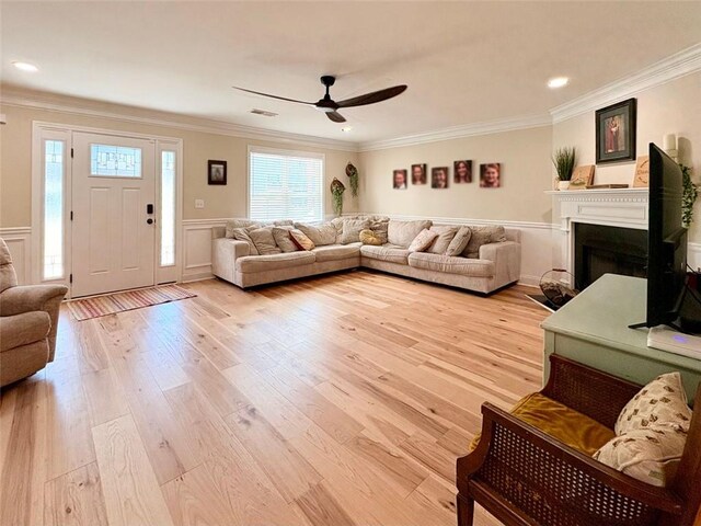 living room featuring crown molding, ceiling fan, and light wood-type flooring