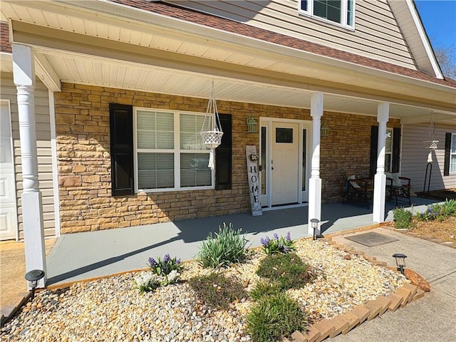 entrance to property with stone siding and a porch