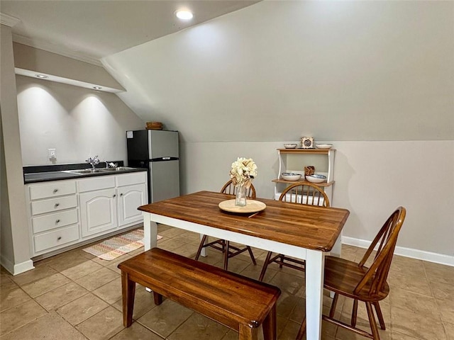 dining room featuring vaulted ceiling and sink