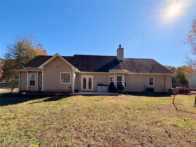 back of property with cooling unit, a patio, a yard, and french doors