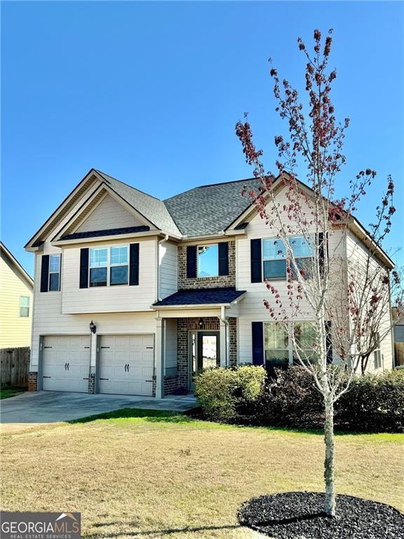 view of front facade with driveway, a front yard, a garage, and fence