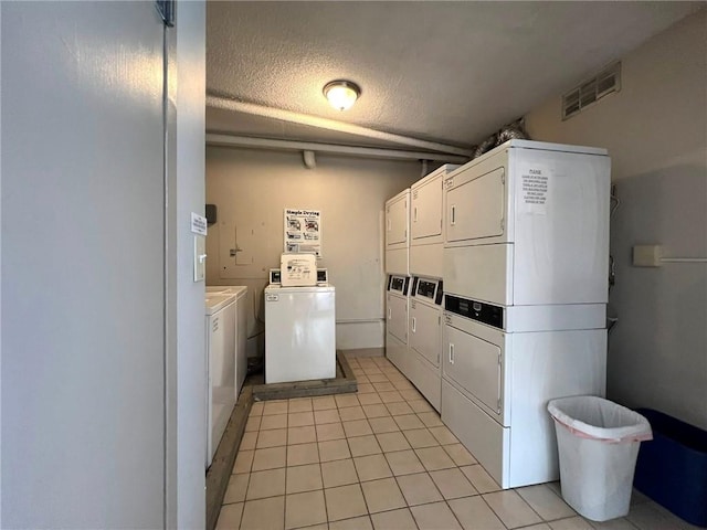 2285 Peachtree Rd NE Unit 1202, Atlanta, GA 30309 - community laundry featuring separate washer and dryer, stacked washer / drying machine, light tile patterned floors, and a textured ceiling