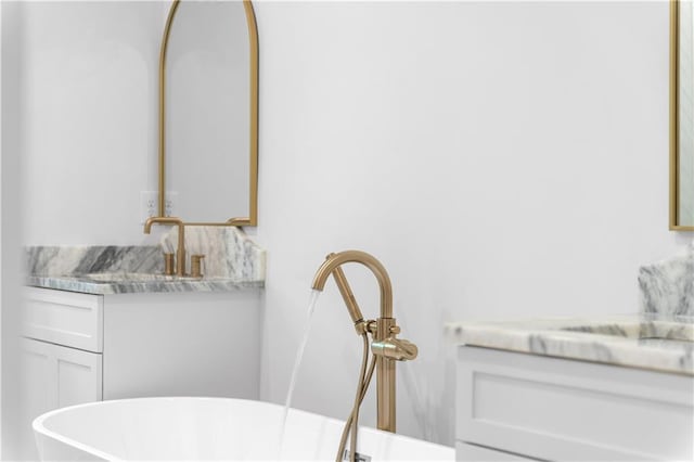 full bathroom with a freestanding bath and vanity