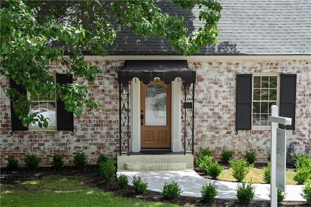 property entrance featuring roof with shingles