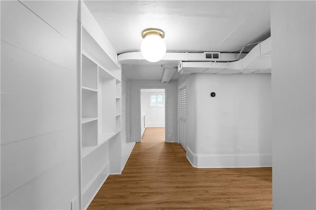 hall with wood finished floors and baseboards