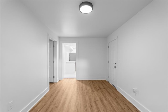spare room featuring baseboards and light wood-style flooring