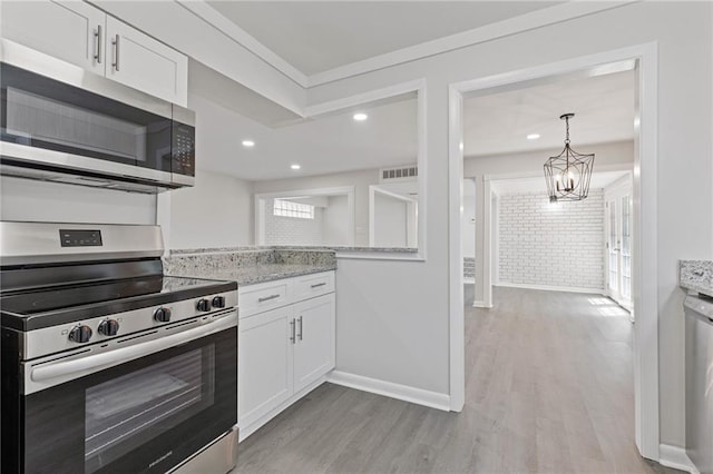 935 Bobcat Ct SE, Marietta, GA 30067 - kitchen featuring stainless steel appliances, light wood-style flooring, white cabinets, a chandelier, and recessed lighting