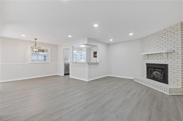 935 Bobcat Ct SE, Marietta, GA 30067 - unfurnished living room featuring a fireplace, wood finished floors, a chandelier, and recessed lighting