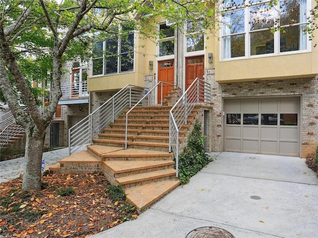 1323 Peachtree Vw NE, Atlanta, GA 30319 - entrance to property with stucco siding, a garage, concrete driveway, and brick siding