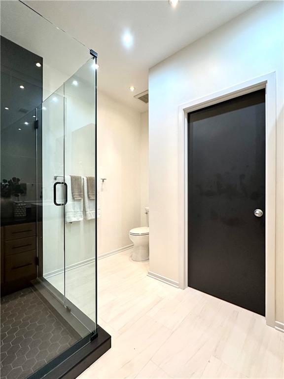 1323 Peachtree Vw NE, Atlanta, GA 30319 - bathroom with a stall shower, recessed lighting, toilet, baseboards, and wood finished floors