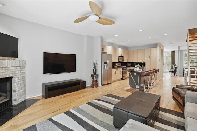1323 Peachtree Vw NE, Atlanta, GA 30319 - living room with light wood finished floors, a brick fireplace, ceiling fan, baseboards, and recessed lighting