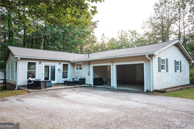 single story home with asphalt driveway, a garage, and roof with shingles