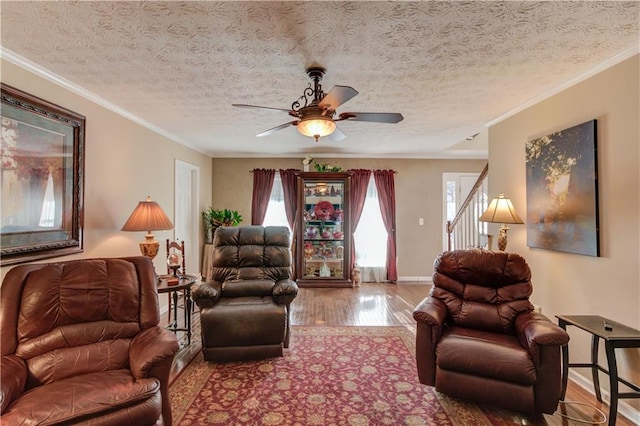 living room featuring crown molding, hardwood / wood-style floors, a textured ceiling, and ceiling fan